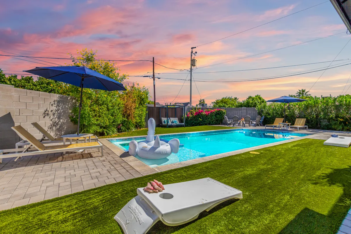 The hero image showcases a stunning backyard oasis at sunset, featuring a sparkling private swimming pool with a playful floating swan, surrounded by inviting lounge chairs and umbrellas. Vibrant flowering plants add a splash of color, while ample space hints at possibilities for outdoor games, sunbathing, and lively gatherings.